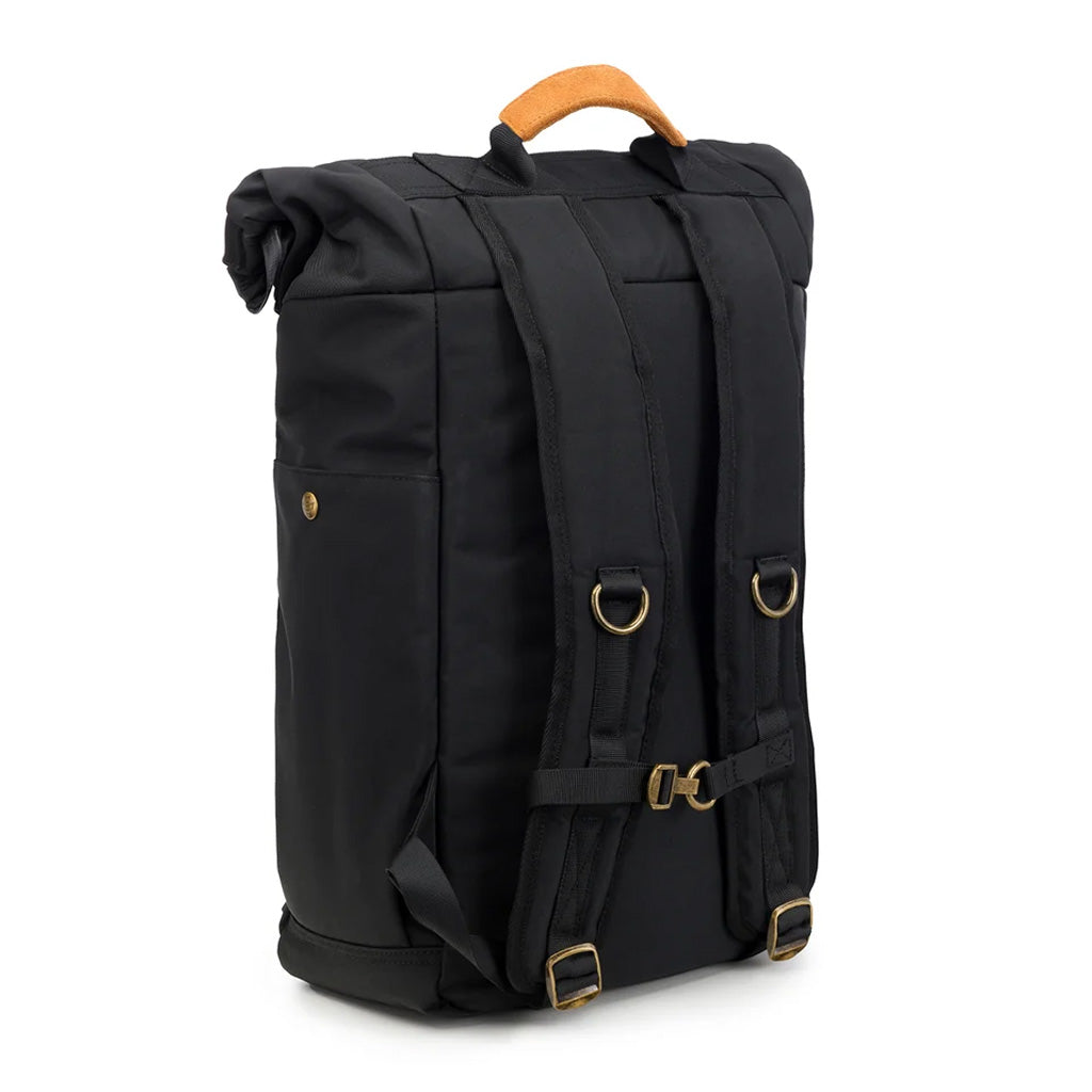 Black Revelry Supply Drifter Backpack on a table setup, highlighting its storage capacity and rolltop design.