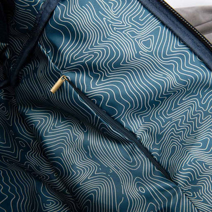 Revelry Supply Drifter backpack in ash color, featuring a rolltop design and adjustable straps set against a plain background.