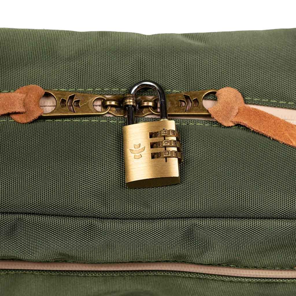 Close-up view of the zipper and fabric texture of the green Revelry Supply toiletry kit.
